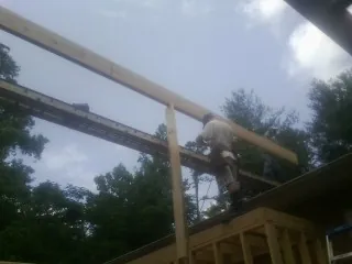 Carpenter setting a ridge beam over a new addition frame — Ice Dam Removal by Roofing Brothers in Palos Hills