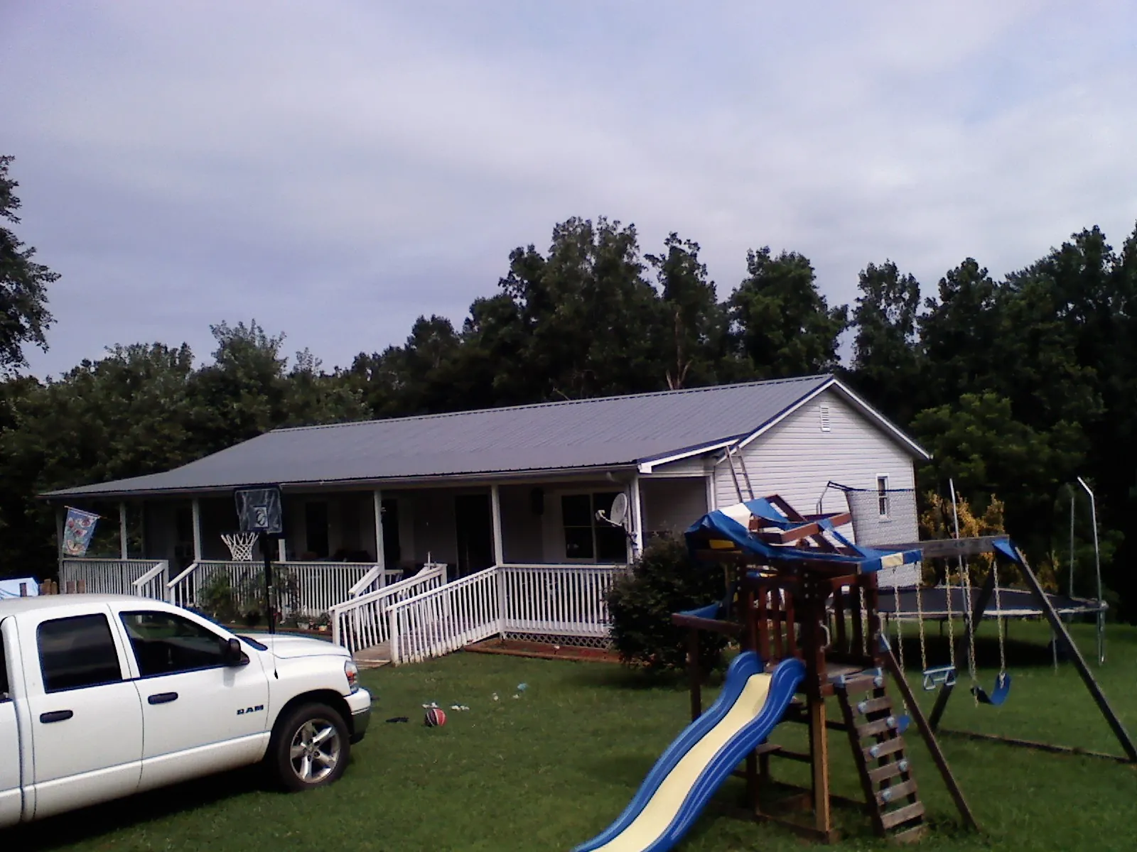 Dark metal roof on a country home with a full length front porch in Palos Hills