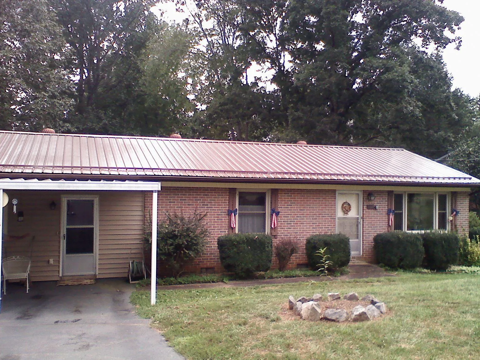 Bronze metal roof and carport on a brick ranch home — Roof Repair work by our crew in Palos Hills